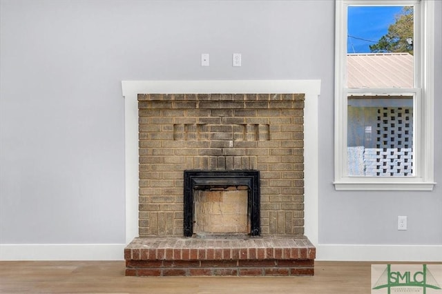 interior details featuring baseboards, a fireplace, and wood finished floors