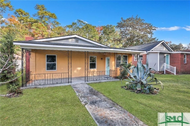 ranch-style home featuring covered porch and a front yard