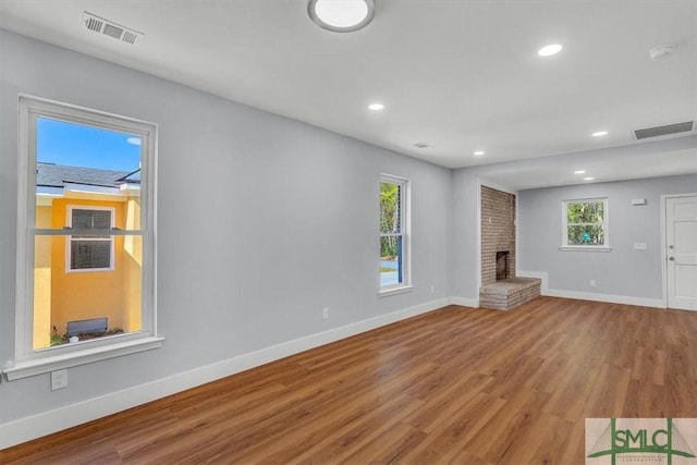 unfurnished living room featuring baseboards, visible vents, wood finished floors, and recessed lighting
