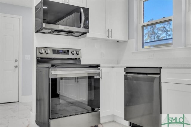 kitchen with decorative backsplash, white cabinets, light countertops, marble finish floor, and stainless steel appliances