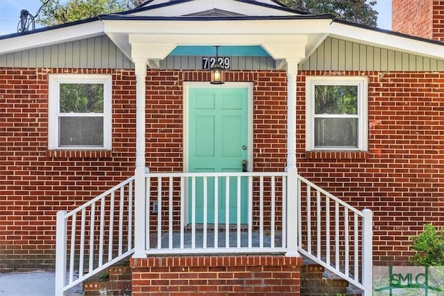 doorway to property featuring brick siding