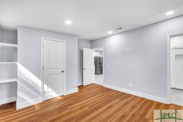 interior space featuring baseboards, wood finished floors, and recessed lighting