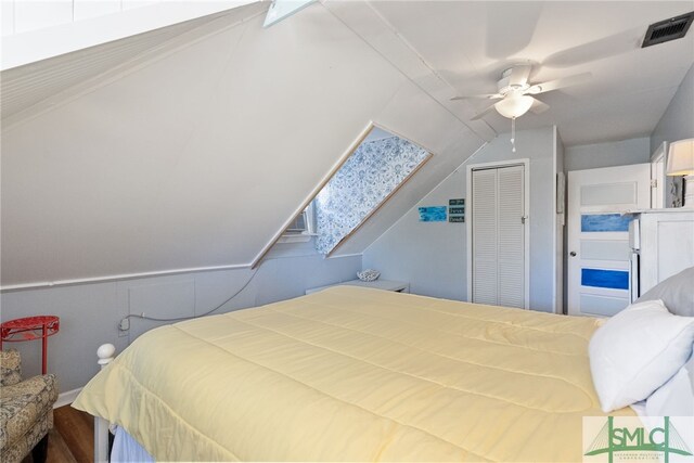 bedroom featuring a ceiling fan, visible vents, a closet, and vaulted ceiling