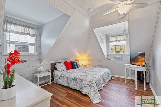 bedroom with cooling unit, baseboards, ceiling fan, and wood finished floors