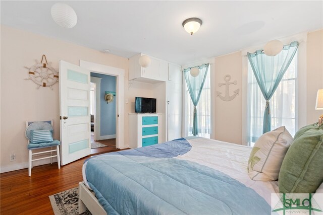 bedroom with baseboards and wood finished floors