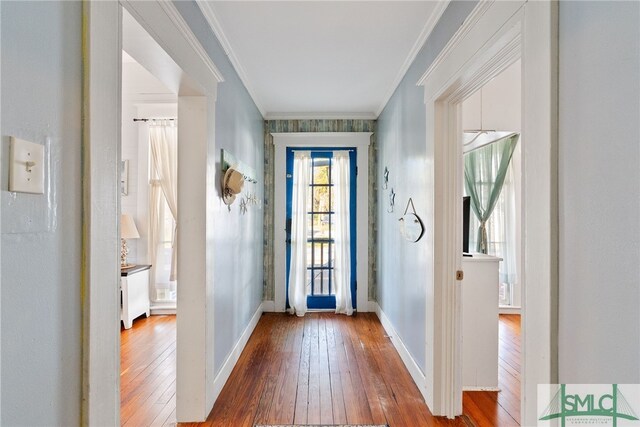 foyer featuring wood-type flooring, crown molding, and baseboards