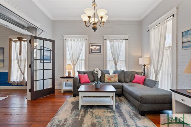 living room with a notable chandelier, ornamental molding, and hardwood / wood-style flooring