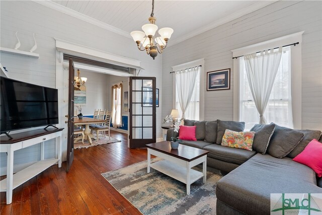 living area with hardwood / wood-style floors, crown molding, and a chandelier