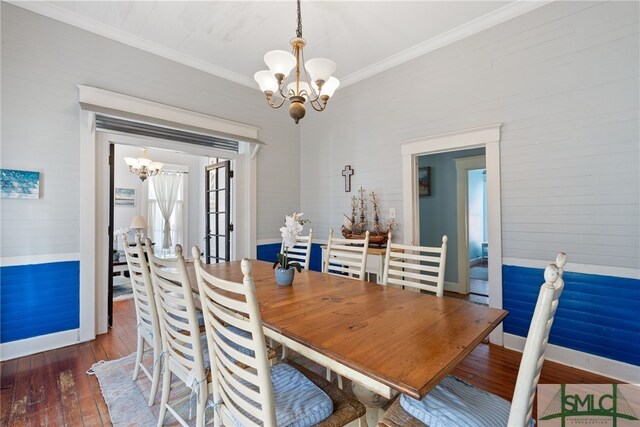 dining room featuring baseboards, ornamental molding, a notable chandelier, and hardwood / wood-style flooring