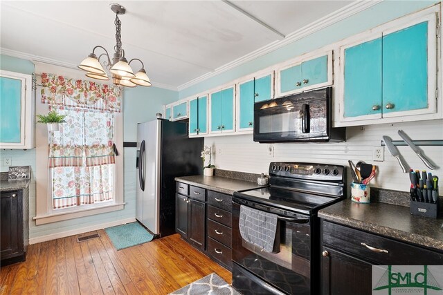 kitchen featuring crown molding, dark countertops, visible vents, black appliances, and light wood-style floors
