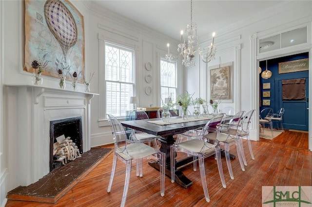 909 Howard St, Savannah, GA 31401 - dining space featuring an inviting chandelier, ornamental molding, a fireplace with raised hearth, and wood finished floors