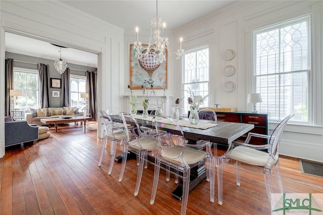 909 Howard St, Savannah, GA 31401 - dining space featuring wood-type flooring, visible vents, crown molding, and an inviting chandelier