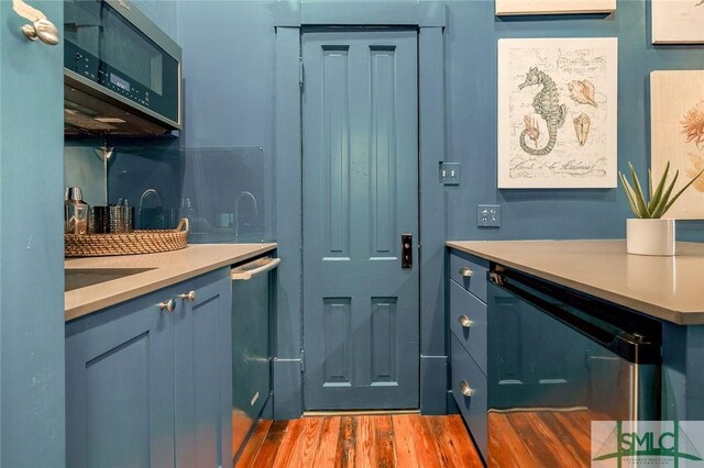 909 Howard St, Savannah, GA 31401 - interior space with light countertops, blue cabinetry, stainless steel appliances, and wood finished floors