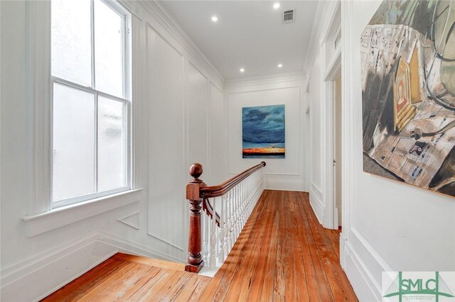 909 Howard St, Savannah, GA 31401 - hallway featuring plenty of natural light, an upstairs landing, a decorative wall, and hardwood / wood-style floors