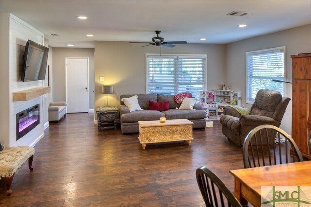 living area with a glass covered fireplace, a ceiling fan, visible vents, and recessed lighting