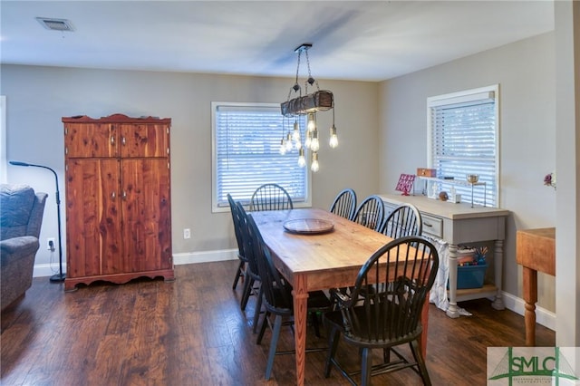 dining space with baseboards, visible vents, and wood finished floors