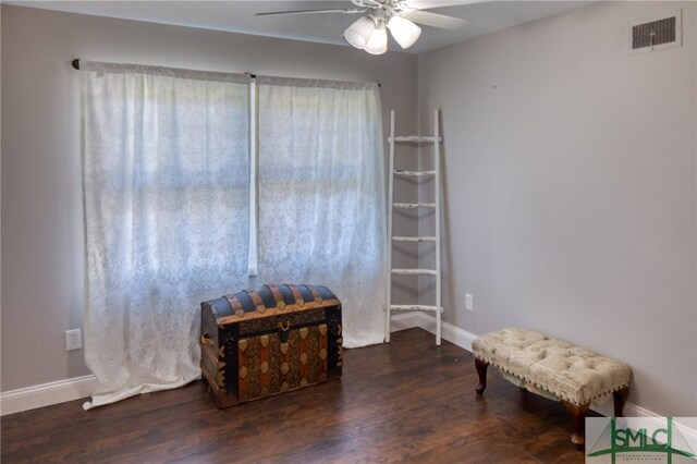 sitting room with a ceiling fan, baseboards, visible vents, and wood finished floors