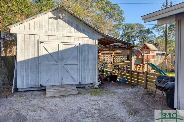 view of shed featuring fence and a playground