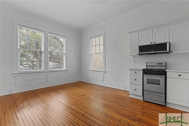 306 E Victory Dr, Savannah, GA 31405 - kitchen with white cabinets, stainless steel appliances, light wood-type flooring, crown molding, and light countertops