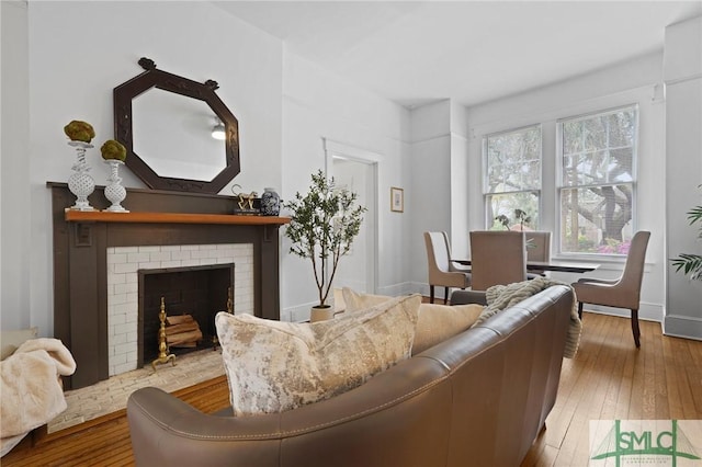 306 E Victory Dr, Savannah, GA 31405 - living area featuring baseboards, a brick fireplace, and hardwood / wood-style floors