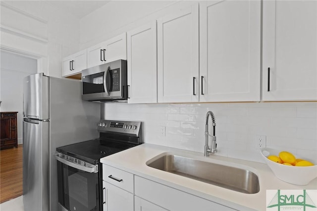 306 E Victory Dr, Savannah, GA 31405 - kitchen featuring white cabinets, a sink, backsplash, light countertops, and appliances with stainless steel finishes