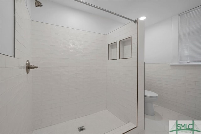 306 E Victory Dr, Savannah, GA 31405 - bathroom featuring a tile shower, tile walls, and toilet