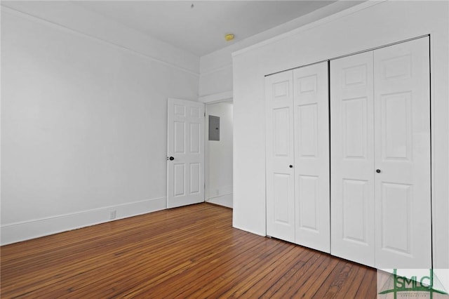 306 E Victory Dr, Savannah, GA 31405 - unfurnished bedroom featuring electric panel, baseboards, wood finished floors, and a closet
