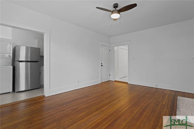 306 E Victory Dr, Savannah, GA 31405 - empty room with hardwood / wood-style flooring, ceiling fan, baseboards, and stacked washing maching and dryer