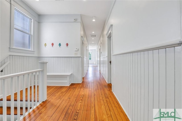 420 E Bolton St, Savannah, GA 31401 - hallway with light wood-style floors, an upstairs landing, visible vents, and a wainscoted wall