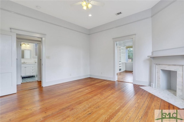 420 E Bolton St, Savannah, GA 31401 - unfurnished living room with baseboards, a fireplace with flush hearth, light wood-style floors, visible vents, and ceiling fan