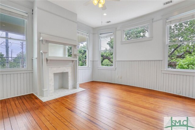 420 E Bolton St, Savannah, GA 31401 - unfurnished living room featuring wood-type flooring, a wainscoted wall, a ceiling fan, and visible vents