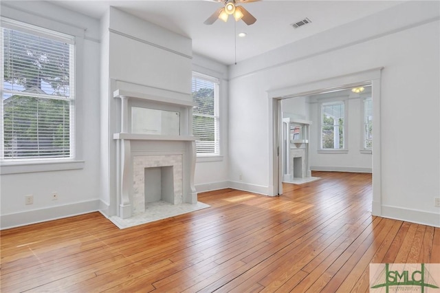 420 E Bolton St, Savannah, GA 31401 - unfurnished living room featuring light wood-style flooring, a ceiling fan, a fireplace with flush hearth, and baseboards