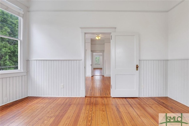 420 E Bolton St, Savannah, GA 31401 - empty room featuring light wood-style floors, a wainscoted wall, and ceiling fan