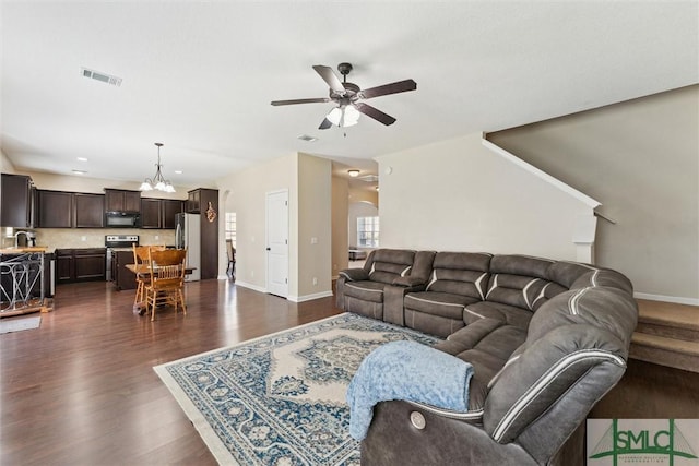 646 Red Oak Ln, Hinesville, GA 31313 - living area with dark wood-type flooring, baseboards, visible vents, and ceiling fan with notable chandelier