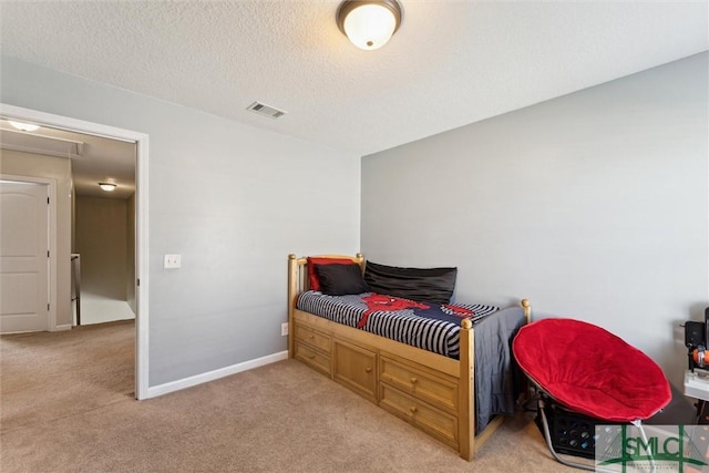 646 Red Oak Ln, Hinesville, GA 31313 - bedroom with light colored carpet, visible vents, baseboards, and a textured ceiling