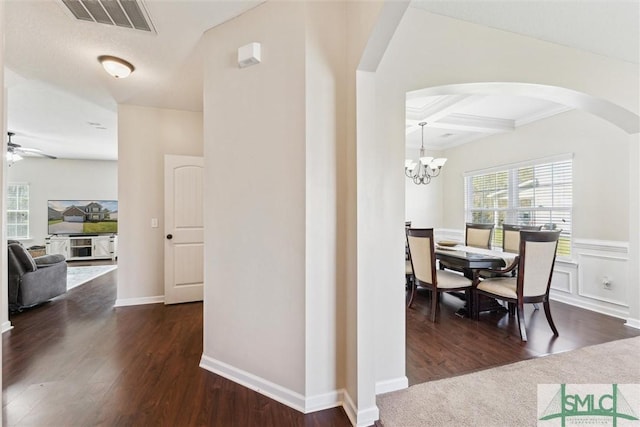 646 Red Oak Ln, Hinesville, GA 31313 - corridor with dark wood-style flooring, visible vents, arched walkways, coffered ceiling, and a notable chandelier
