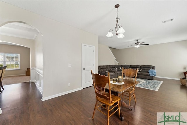 646 Red Oak Ln, Hinesville, GA 31313 - dining area with baseboards, ceiling fan with notable chandelier, visible vents, arched walkways, and dark wood-style flooring