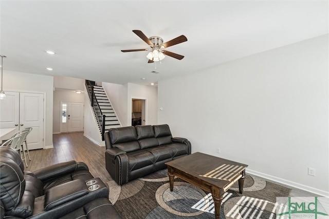 148 Spring Hill Dr, Richmond Hill, GA 31324 - living area featuring baseboards, wood finished floors, stairway, and a ceiling fan