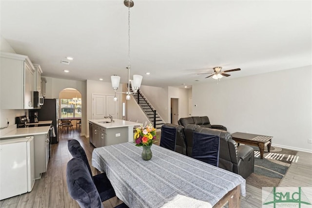 148 Spring Hill Dr, Richmond Hill, GA 31324 - dining room with stairs, a ceiling fan, light wood-type flooring, arched walkways, and recessed lighting