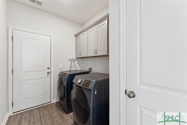 148 Spring Hill Dr, Richmond Hill, GA 31324 - washroom with independent washer and dryer, baseboards, light wood finished floors, visible vents, and cabinet space