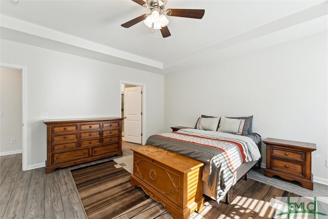 148 Spring Hill Dr, Richmond Hill, GA 31324 - bedroom with baseboards, ceiling fan, wood finished floors, and a raised ceiling