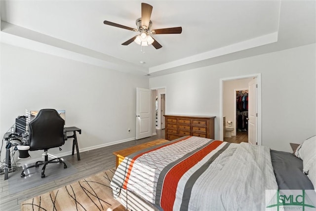 148 Spring Hill Dr, Richmond Hill, GA 31324 - bedroom featuring a ceiling fan, a tray ceiling, baseboards, and wood finished floors