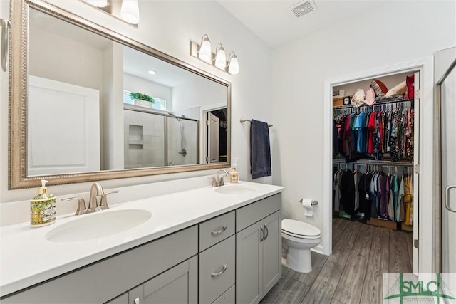 148 Spring Hill Dr, Richmond Hill, GA 31324 - bathroom featuring double vanity, a sink, a stall shower, and visible vents