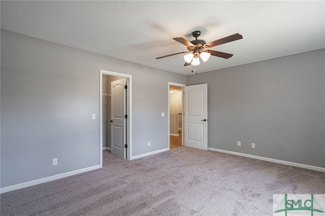 402 Walthour Dr, Rincon, GA 31326 - unfurnished bedroom with carpet flooring, a walk in closet, baseboards, a ceiling fan, and a textured ceiling