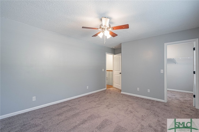 402 Walthour Dr, Rincon, GA 31326 - unfurnished bedroom featuring carpet, baseboards, a textured ceiling, a walk in closet, and a ceiling fan