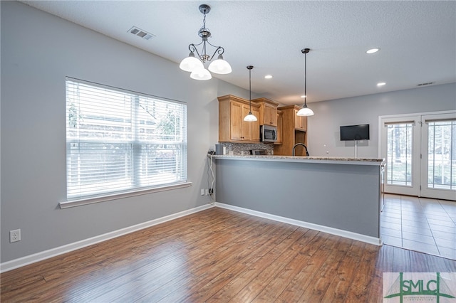 402 Walthour Dr, Rincon, GA 31326 - kitchen with stainless steel microwave, wood finished floors, recessed lighting, a peninsula, and baseboards
