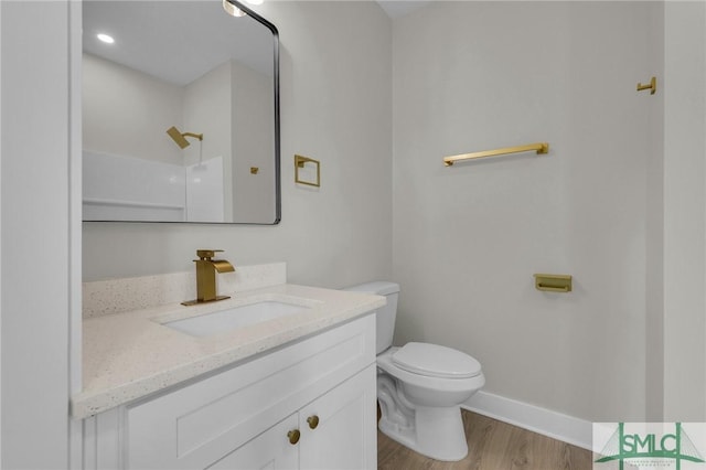 full bathroom with toilet, baseboards, walk in shower, vanity, and wood finished floors