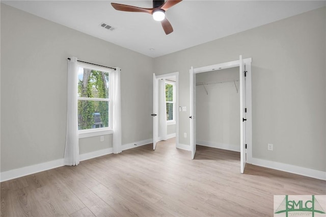 unfurnished bedroom featuring a closet, visible vents, ceiling fan, baseboards, and light wood-style floors