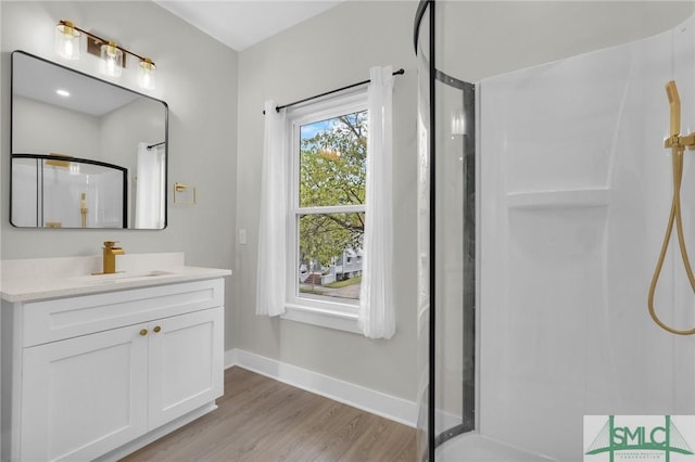 bathroom featuring a shower stall, baseboards, vanity, and wood finished floors