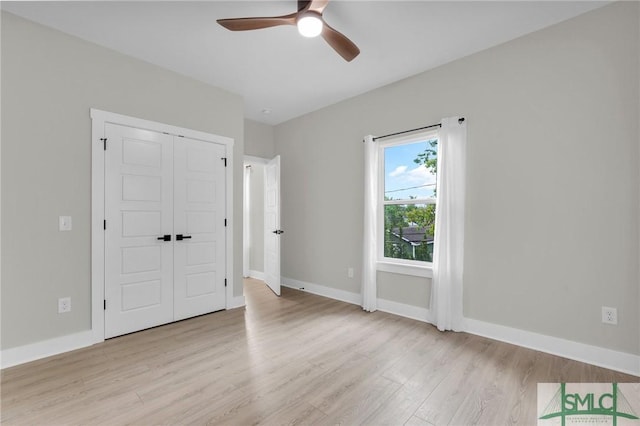 unfurnished bedroom featuring baseboards, light wood-style floors, a closet, and ceiling fan